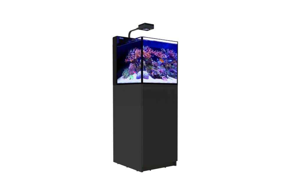 Red Sea MAX Nano Peninsula all-in-one reef aquarium with LED lighting, built-in filtration, and a modern black cabinet for saltwater fish and corals.